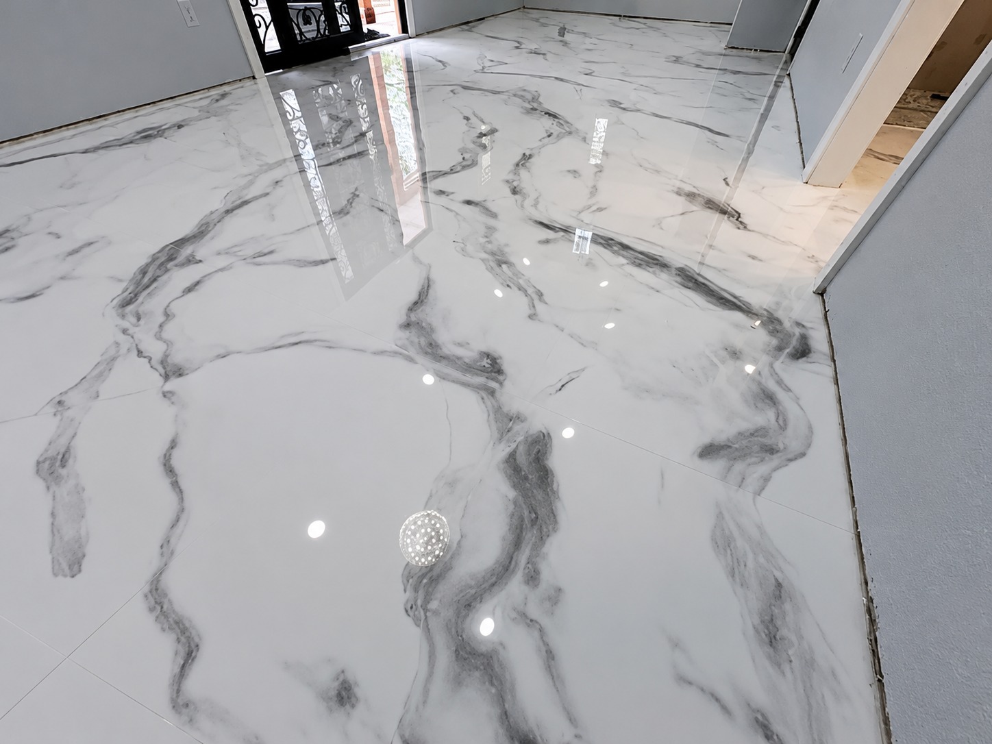 Large-format marble porcelain floor with mirror reflection